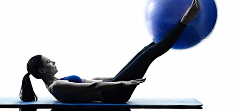 Frau mit blauem Ball auf Matte